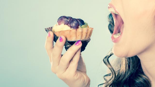 摄图网_304114287_甜美的食物浸泡和脂肪的概念妇女面对张开的嘴吃蛋糕用过滤的照片（企业商用）.jpg